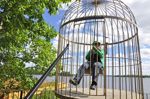 Karen Duquette in a large bird cage